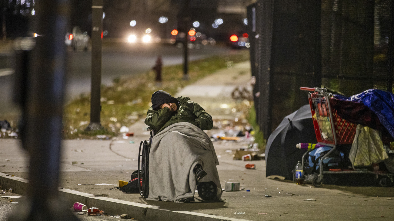 BOSTON, MA - NOVEMBER 17: A homeless man in a wheelchair sleeps on Massachusetts Avenue at 6AM on Nov. 17, 2020. (Photo by Stan Grossfeld/The Boston Globe via Getty Images)